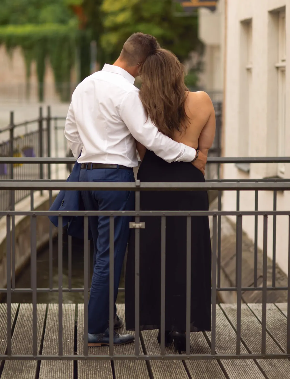 Ein Paar steht Arm in Arm an einem Geländer